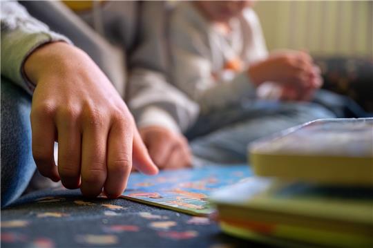 Eine Praktikantin liest in einer Kita Kindern vor..