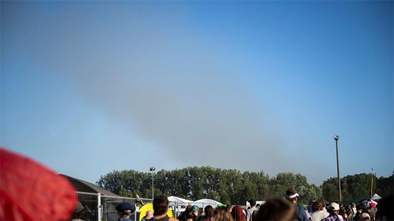 Eine Rauchsäule steigt unweit des Festivalgeländes in die Luft.