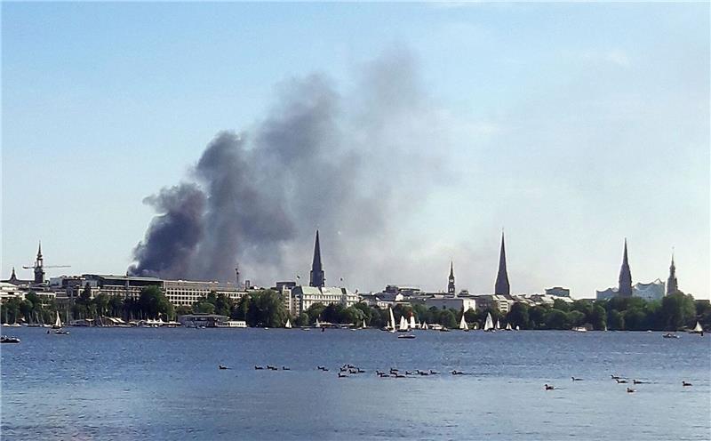 Brand auf Baustelle in Hamburgs Hafencity Eine Rauchwolke ist über der Alster in Hamburg zu sehen. Auf einem zehnstöckigen Haus in der Hamburger HafenCity ist es am Freitagnachmittag zu mehreren Explosionen gekommen.