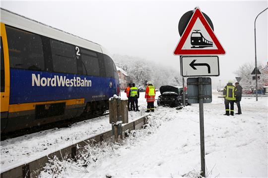 Eine Regionalbahn der NordWestBahn und ein PKW stehen nach einem Unfall an einem Bahnübergang. Warum es am Morgen um kurz nach 8 Uhr zu dem Zusammenprall in Emmenhausen kam, ist laut Polizei noch unklar. Foto: picture alliance/dpa | Stefan Rampfel