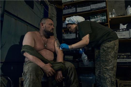 Eine Sanitäterin verarztet einen ukrainischen Soldaten in Bachmut.