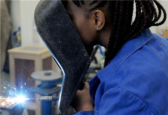 Eine Schülerin aus dem afrikanischen Guinea absolviert in der Metallwerkstatt der Allgemeinen Berufsschule in Bremen einen Kurs im E-Schweißen.