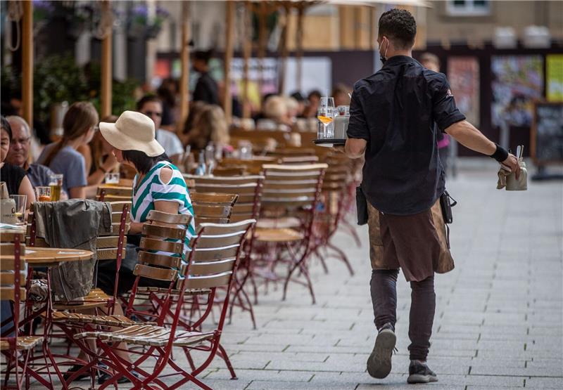 Crif-Analyse: Jedem zehnten Gastro-Betrieb droht die Pleite Eine Servicekraft bedient im Außenbereich eines Restaurants die Gäste.