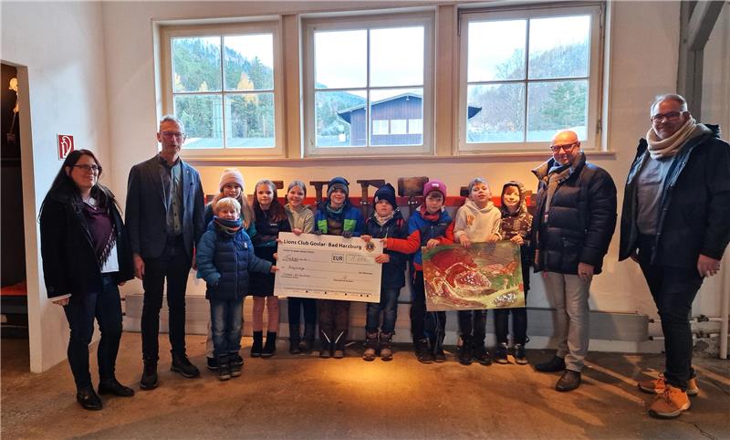 Eine neue Kamera für die Rammelsberger Bergzwerge Eine Spende und ein Kunstwerk als Dankeschön: Gesine Reimold und Johannes Großewinkelmann vom Rammelsberg, die kleinen Bergzwerge sowie Mike Hickmann und Norman Heyke vom Lionsclub Goslar- Bad Harzburg (v.l.)