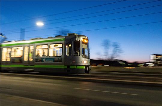 Eine Stadtbahn der ÜSTRA Hannoversche Verkehrsbetriebe fährt in der Morgendämmerung über eine Brücke. Foto: dpa