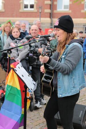 Eine Straßenmusikerin spielt Gitarre.