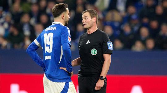 Eine Szene vom vergangenen Spieltag der 2. Fußball-Bundesliga. Schiedsrichter Robin Braun spricht dem FC Schalke 04 im Spiel gegen den FC Kaiserslautern zunächst einen Handelfmeter zu, der nach der Videoanalyse kassiert wird. Er und Schalkes Kapitän Kenan Karaman diskutieren die Situation. Foto: picture alliance/dpa