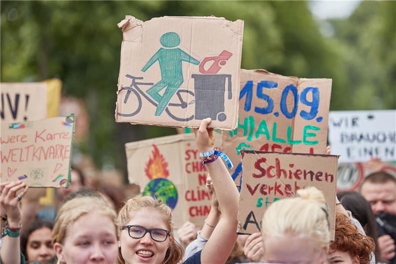 Eine Teilnehmerin eines Protestzugs der Klimabewegung Fridays for Future trägt ein Pappschild.