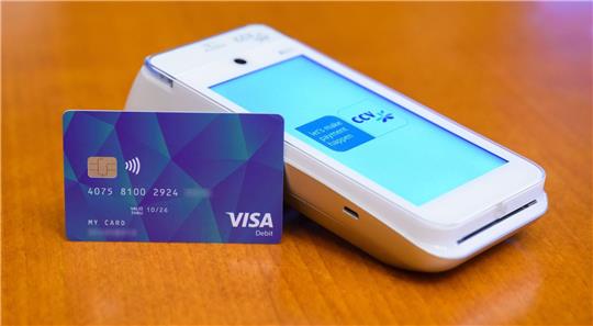 Eine VISA-Debit Karte für Geflüchtete liegt im Rathaus Hannover neben einem Lesegerät.