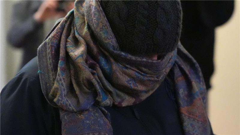 Eine Zeugin verlässt vermummt den Gerichtssaal.