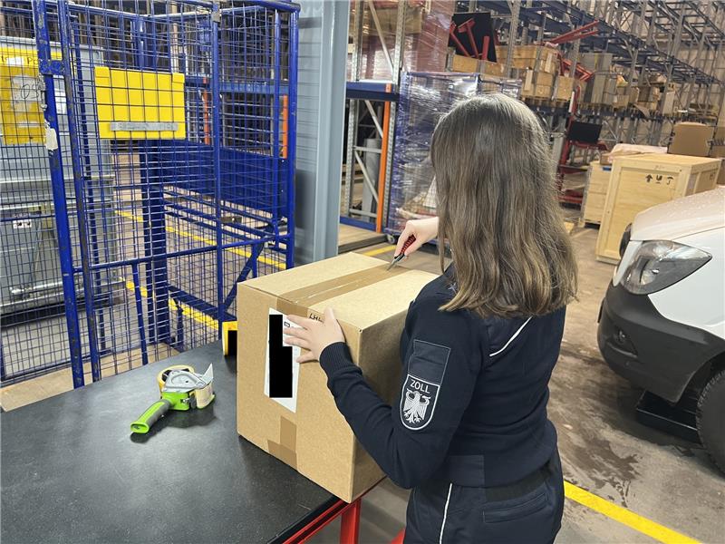 Kuriose Paketfunde: Mäusehirn, Pickelhaube und Sexpuppe Eine Zollbeamtin öffnet ein Paket zur genaueren Überprüfung. Foto: Hauptzollamt Braunschweig