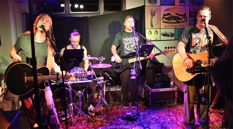 Das Bild zeigt eine Band, die in einer Kneipe spielt.