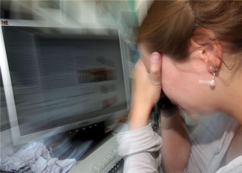 Eine depressive Frau an ihrem Arbeitsplatz.