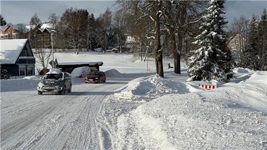 Das Foto zeigt eine Straße mit einer festgefahrenen Schneedecke.