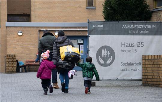 Eine geflüchtete Familie betritt eine Erstaufnahmestelle. Foto: Paul Zinken