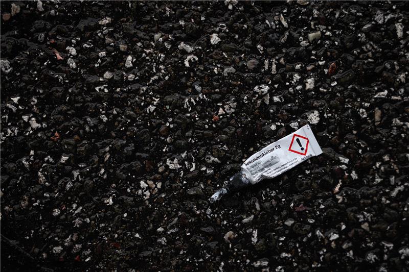 Aschersleben: Junge entführt und an Metallstange festgeklebt? Eine leere Tube Sekundenkleber liegt an der Fahrbahn. Symbolbild: picture alliance/dpa | Christian Charisius