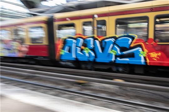 Eine mit einem Graffiti besprühte S-Bahn fährt aus dem Berliner Ostbahnhof.
