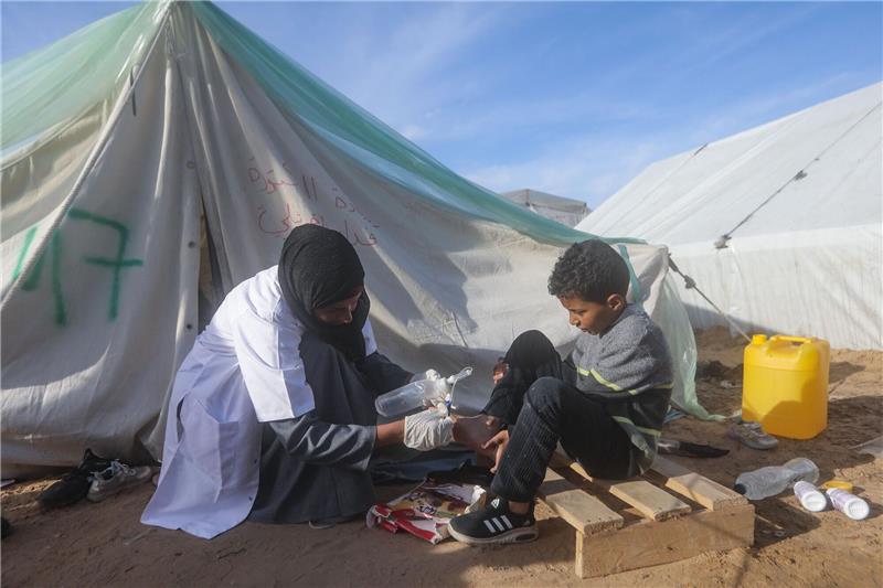 WHO: Unnötige Amputationen wegen Notlage im Gazastreifen Eine palästinensische Ärztin behandelt einen Jungen vor ihrer Zeltklinik in Rafah.