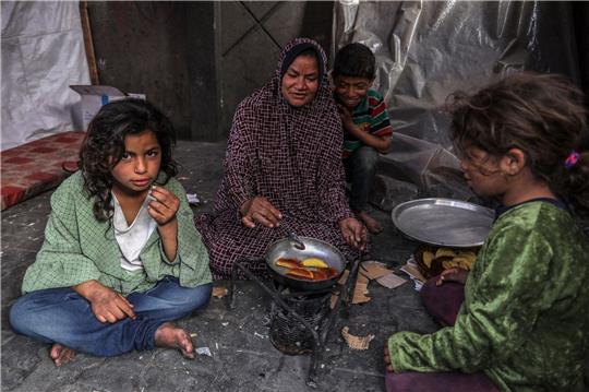 Eine palästinensische Familie kocht in einem behelfsmäßigen Zelt in Rafah.