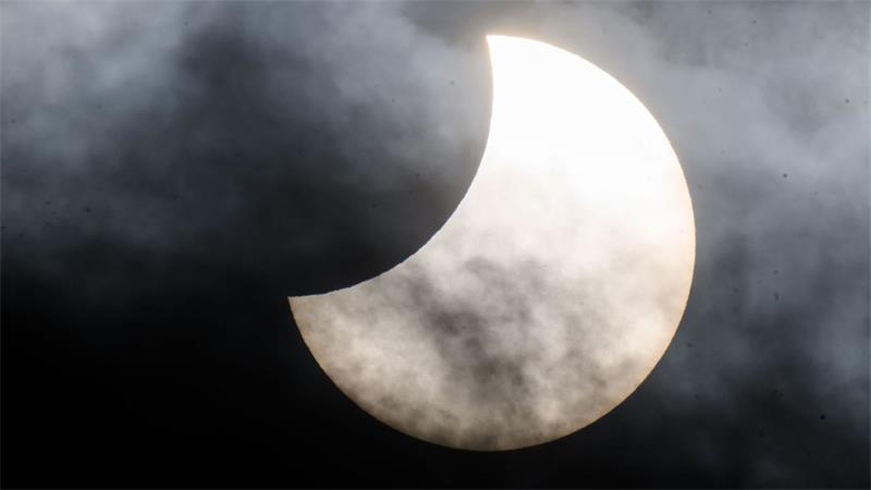 Eine partielle Sonnenfinsternis ist zwischen Wolken am Himmel zu sehen. (Archivbild)