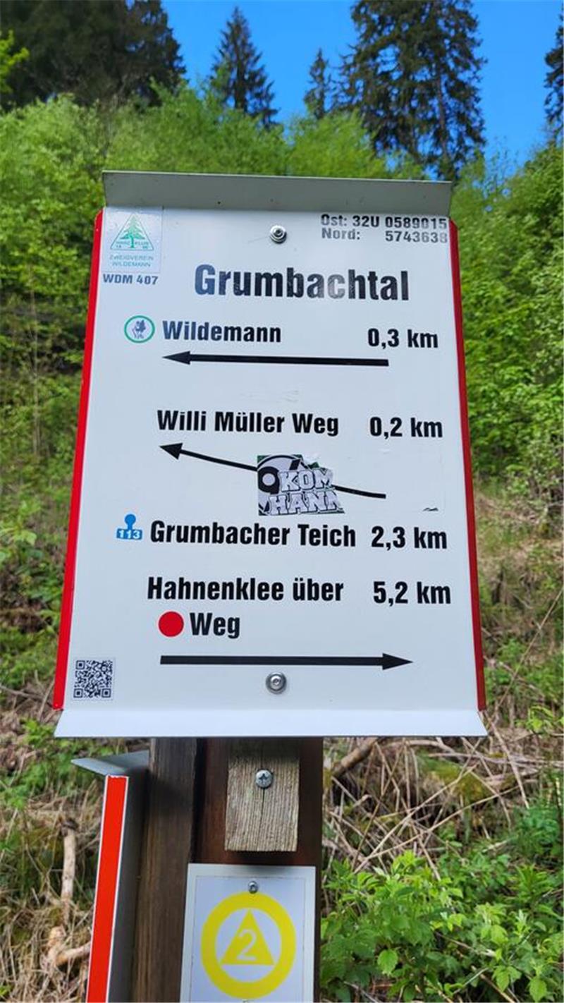 Ein weißes Schild mit Richtungsangaben.