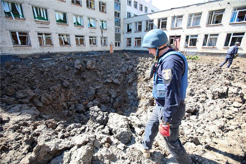 Krieg gegen die Ukraine: So ist die Lage Eine ukraininische Sicherheitskraft inspiziert das Gelände einer Schule in Charkiw nach russischem Beschuss.