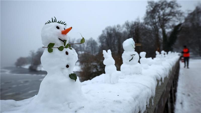 Eine ungewöhnliche Ausstellung: Zahlreiche kleine und winzige Schneefiguren stehen auf einer Mauer der Krugkoppelbrücke an der Alster im Hamburg.