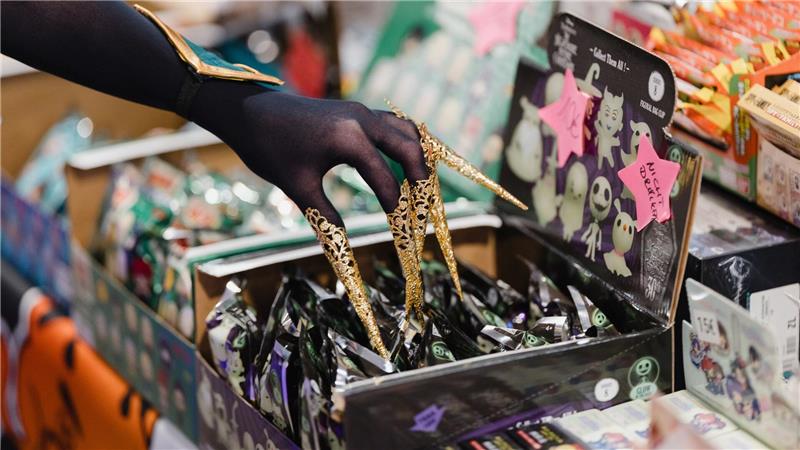 Eine verkleidete Messebesucherin berührt auf der Manga- und Comic-Messe „MAG-C“ ausgestellte Produkte. 