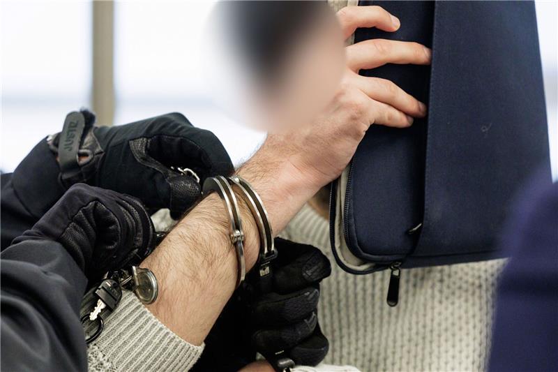 Juwelendiebstahl-Prozess in Dresden geht bis weit in Februar Einer der Angeklagter wird von Justizbeamten in Handschellen in den Gerichtssaal des Oberlandesgerichts Dresden geführt.