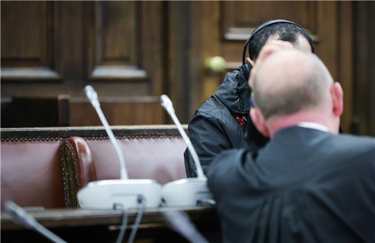 Einer der beiden Angeklagten (verdeckt) spricht mit seinem Anwalt Hannes Linke vor Prozessbegin im Gerichtssaal im Strafjustizgebäude.