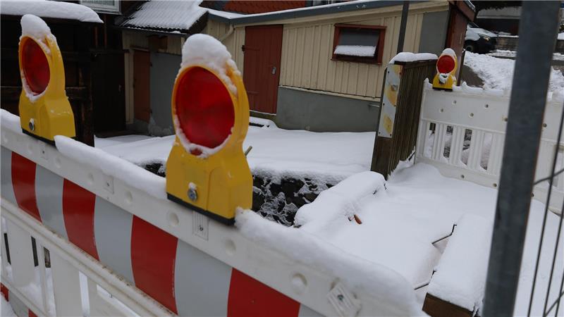 Im Vordergrund stehen Absperrungen. Dahinter liegt ein kaputter Teil einer Brücke.