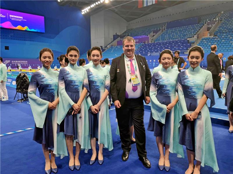 Goslarer bei Asian Para Games: Wie in einer anderen Welt Eingekleidet vom Veranstalter sind die Offiziellen der Asian Para Games leicht zu erkennen. Der Goslarer Kampfrichter Ingmar Hahn in der riesigen Schwimmhalle umringt von einigen Helferinnen. Foto: Privat