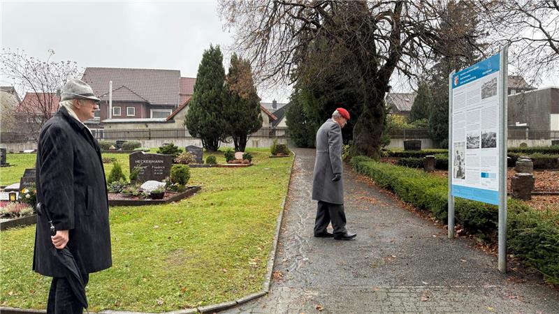 Einige wenige, unter ihnen Ortsvorsteher Karl-Heinz Plosteiner, gehen im strömenden Regen zu dem Platz auf dem Friedhof St. Andreasberg