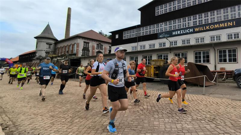 Einmaliges Ambiente: Start und Ziel des Steigerlaufs befinden sich auf dem Gelände des Bergwerks, wo es noch eben dahergeht. Dann kommen schnell die Steigungen.