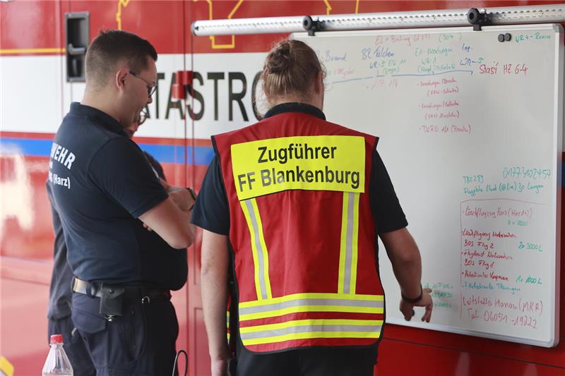 Einsatzkräfte an der Einsatzleitstelle der Feuerwehr in Schierke planen die Wald...