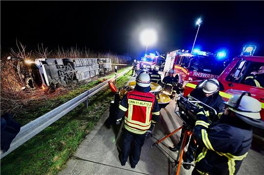 Einsatzkräfte der Feuerwehr arbeiten an einer Unfallstelle auf der Autobahn 44 (A44) an einem verunfallten Bus.