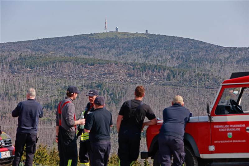 Einsatzkräfte der Feuerwehr beobachten vom niedersächsischen Wurmberg aus das Waldbrandgebiet Anfang Juni am Brocken. Bei einem Waldbrand im Harz konnten die Einsatzkräfte das Feuer unter Kontrolle bringen. Doch jetzt kursieren Gerüchte zur Brandursache. Foto: Matthias Bein / dpa