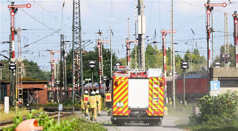 Einsatzkräfte der Feuerwehr fahren und laufen durch den Güterbahnhof Seelze in der Region Hannover.