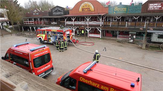Einsatzkräfte der Feuerwehr stehen stehen in der Westernstadt Pullman City Harz in Hasselfelde. Am Vormittag kam es hier zu einem Gebäudebrand in einer Gaststätte.