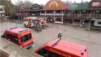 Einsatzkräfte der Feuerwehr stehen stehen in der Westernstadt Pullman City Harz in Hasselfelde. Am Vormittag kam es hier zu einem Gebäudebrand in einer Gaststätte.