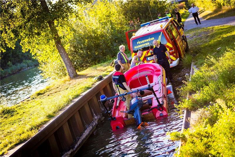 Einsatzkräfte der Feuerwehr ziehen ein Feuerwehrboot aus dem Mittellandkanal in Hannover-Vinnhorst.