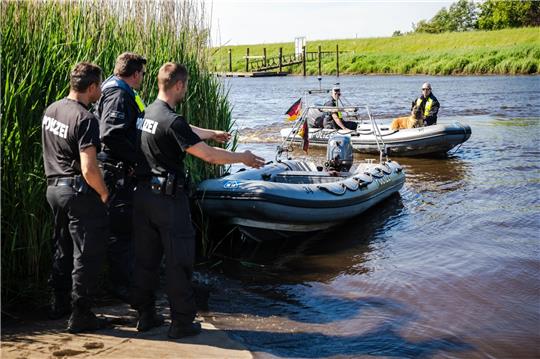 Einsatzkräfte der Polizei fahren bei der Suche nach dem vermissten Arian mit Spürhunden auf Schlauchbooten über die Oste.