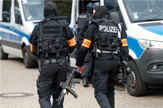 Einsatzkräfte der Polizei gehen vor einer Realschule in Siegburg. Angeblich wurden in der Schule Personen mit Waffen gesehen. Foto: Henning Kaiser/DPA