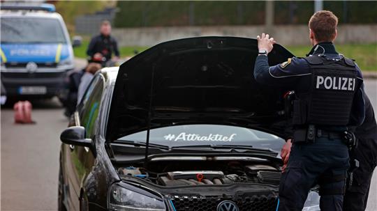 Polizisten kontrollieren ein Auto.