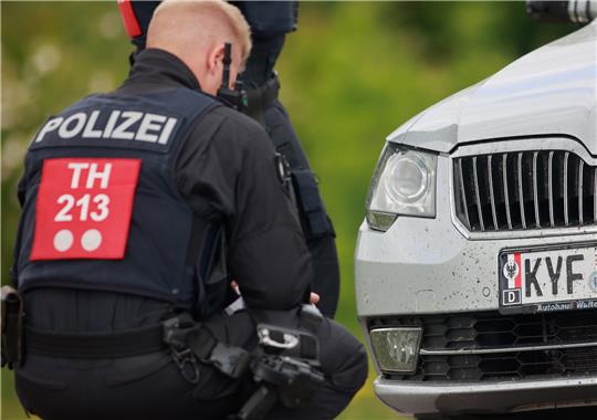 Einsatzkräfte der Polizei kontrollieren vor einem Veranstaltungsgelände anreisende Teilnehmer eines mutmaßlichen Reichsbürgertreffens und stellen dabei ein verändertes Kennzeichen an einem Fahrzeug fest. Foto: picture alliance/dpa | -
