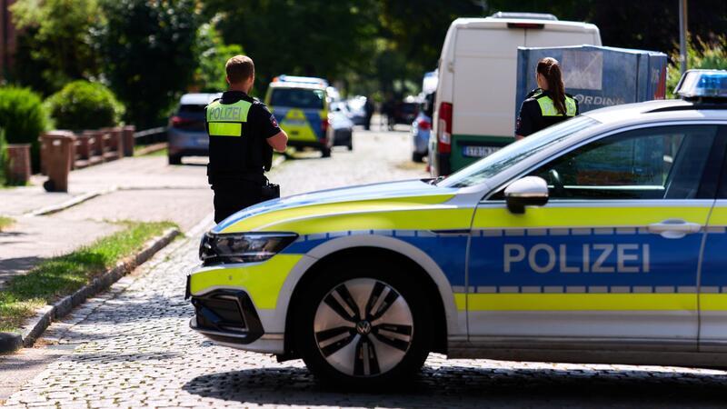 Einsatzkräfte der Polizei stehen auf einer Straße vor einer Jugendeinrichtung. In der Einrichtung sind mehrere Menschen durch Schüsse gestorben. Der Täter soll ein Mann sein, der in Goslar geboren wurde. Er nahm sich mittlerweile das Leben.