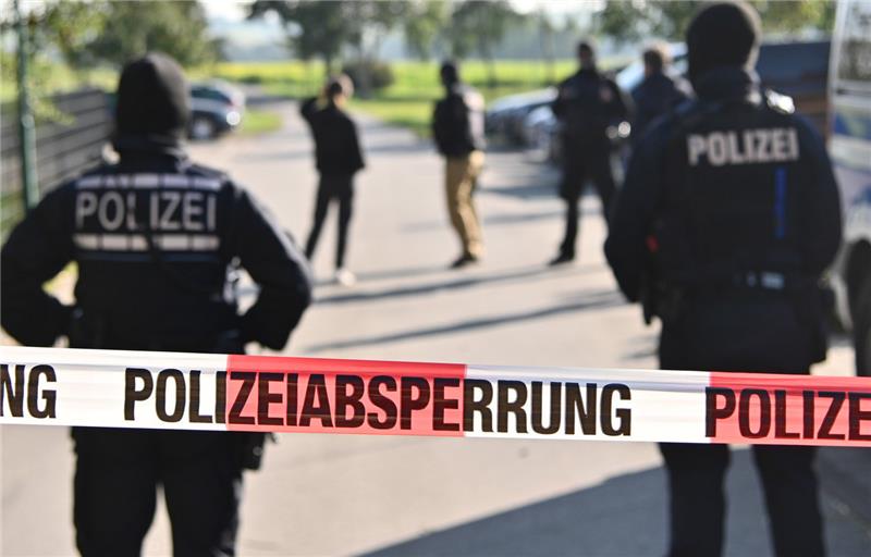 Einsatzkräfte der Polizei stehen hinter einer Polizeiabsperrung. Symbolfoto: picture alliance/dpa | Jan-Philipp Strobel