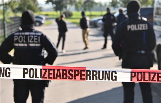 Einsatzkräfte der Polizei stehen hinter einer Polizeiabsperrung. Symbolfoto: picture alliance/dpa | Jan-Philipp Strobel