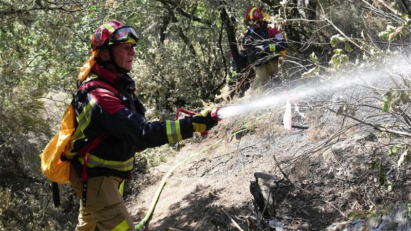 Einsatzkräfte einer für Waldbrände spezialisierten Feuerwehr aus Nordrhein-Westfalen unterstützen die Brandbekämpfung im Waldbrandgebiet in der Nähe der Ortschaft Moreda.