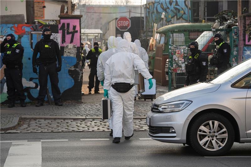 Polizei durchsucht bei RAF-Fahndung Wagenburg und Wohnung Einsatzkräfte gehen auf ein Grundstück.